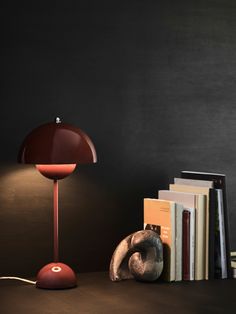 a lamp that is on top of a table next to books and a teddy bear