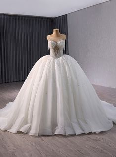 a white wedding dress on display in a room