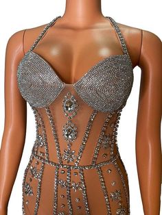 a mannequin wearing a dress with lots of silver beads on the bust and shoulders