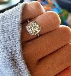 a woman's hand with a diamond ring on it