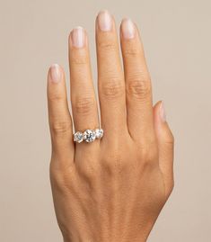 a woman's hand with a three stone ring on it