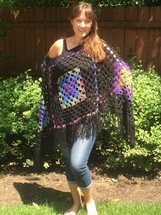 This beautiful, hand-crocheted poncho is a classic,  It is made of extra-soft acrylic and wool yarns.  The main color is black with green, blue and purple accents. This poncho is the perfect accessory.  Ideal for an summer evening at a festival or an early spring/fall hike. You can wear it over a coat or light jacket.  Ponchos are versatile and always in style. This stylish and super-soft poncho is easy to care for:  Machine wash in cool water.  Lay flat to dry.  Do not dry clean. Size:  One Siz Boho Grandma, Boho Granny Square, Granny Square Poncho, Fall Hike, Girls Poncho, Boho Poncho, Granny Square Crochet Patterns Free, Barbie Costume, Ladies Poncho