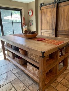 a kitchen island made out of wood with baskets on the top and drawers below it