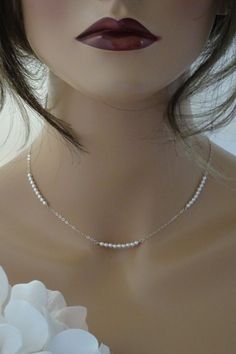 This minimalist wedding necklace with its simple pearl design will add a bit of tradition to your modern bridal style. A dainty and elegant choker necklace. Elegant Backdrop Necklace Choker For Gifts, Elegant Backdrop Choker Necklace As Gift, Minimalist Pearl Choker Jewelry, Minimalist Pearl Chain Choker, Minimalist Pearl Charm Choker, Dainty Sterling Silver Bridal Necklace, Minimalist White Pearl Chain Backdrop Necklace, Classic Wedding Choker With Pearl Drop, Minimalist Pearl Backdrop Necklace For Wedding