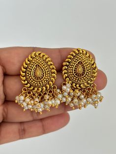 Antique Pearl Gold Studs Earrings /Indian Studs/Indian Earrings/Indian Jewelry/Pearl Stud/Bridal Jewelry/Indian wedding/South Indian Jewelry Style 1 Height = 38 Mm || Width = 30 Mm Tops Antique Earring Style 2 Height = 35 Mm || Width = 34 Mm Tops Antique Earring This is 100% Handmade jewelry. So Color, shades, texture displayed may slightly vary from the actual product due to digital image limitations. We request you to consider these minor variations. Please expect the possibility of some sligh Temple Jewelry Bridal Earrings With Pearl Drop For Wedding, Temple Style Bridal Earrings With Pearl Drop For Wedding, Round Pearl Earrings With Latkans For Wedding, Wedding Pearl Drop Jhumkas, Wedding Temple Jewelry Pearl Earrings, Elegant Chandbali Earrings For Marriage, Dangle Pearl Earrings With Latkans For Wedding, White Pearl Earrings With Latkans For Wedding, Traditional Pearl Drop Earrings For Anniversary