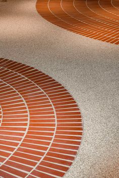 an orange and white tiled floor in a room with red bricks on the ground next to it