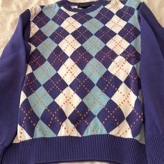 New . Never Worn . Vintage Circa 2005 Purchase And Never Worn . Bobby Jones Collection Argyle Golf Sweater. Crew Neck. 100% Cotton. Solid Lavender Blue Sleeves With Lavender Blue, Light Blue And White Argyle Pattern With An Orange Stripes Front And Rear. Size Medium Golf Fit Allows Plenty Of Movement. Shoulder To Shoulder 18 1/2”. Armpit To Armpit 22”. Length 25 1/2”. This Is A Great Looking Sweater Sure To Make A Statement On Or Off The Links. Casual Cotton Sweater With Argyle Pattern, Casual Cotton Argyle Sweater, Casual Long Sleeve Argyle Pattern Tops, Casual Long Sleeve Argyle Top, Casual Argyle Pattern Crew Neck Tops, Casual Argyle Crew Neck Tops, Casual Cotton Tops With Argyle Pattern, Casual Argyle Pattern Crew Neck Sweater, Preppy Blue Cotton Sweater