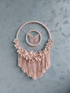 a dream catcher hanging on the wall next to a blue wall with flowers and a butterfly