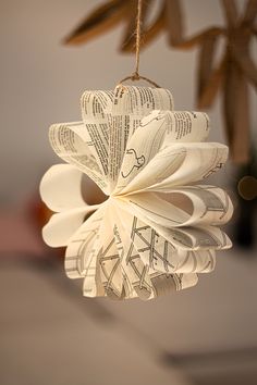 an ornament made out of book pages hanging from a string