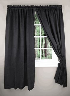 a window with black curtains in front of it and trees outside the window sill