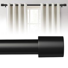 black and white curtains hanging in front of a window with the curtain rod pulled back