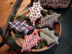 a wooden bowl filled with cloth ornaments on top of a table