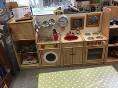 a child's play kitchen with lots of wooden furniture