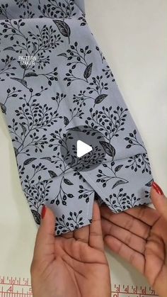 someone is holding up a piece of fabric with flowers on it and the bottom half has been folded