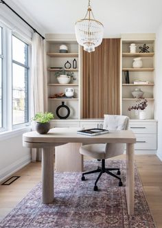 a room with a table, chair and shelves in it that have vases on them