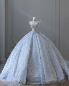 a blue ball gown on display in front of a white wall