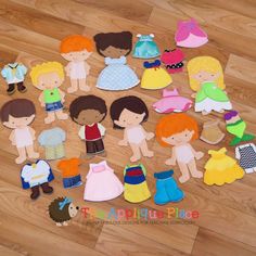 a group of paper dolls sitting on top of a wooden floor