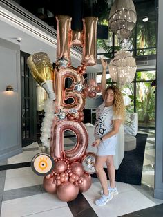 two women standing in front of a giant balloon letter