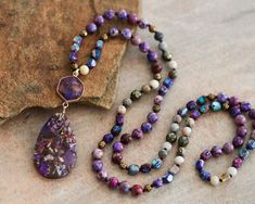 "Approx. 34\" L. Pendant size: 1.2\"x3\" Color, size, pattern may vary. Elevate your style with our enchanting Purple Sea Sediment Imperial Jasper Necklace, featuring a substantial stone pendant for a bold and distinctive look. Meticulously handcrafted, this necklace is not just a stunning accessory but also a symbol of stability and healing. The large Purple Sea Sediment Imperial Jasper pendant takes center stage, displaying a mesmerizing blend of deep purples and rich blues. Known for its stabilizing energy, this gemstone promotes a sense of calm and balance. The necklace goes beyond mere fashion, offering a connection to the earth's energies and a shield of healing crystal protection. Measuring approximately 34 inches, the knotted design showcases the natural beauty of Purple Sea Sedime Multicolor Jasper Spiritual Necklace, Spiritual Multicolor Jasper Necklaces, Crystal Protection, Purple Sea, Imperial Jasper, Jasper Necklace, Protection Necklace, Stone Pendant Necklace, Jasper Pendant