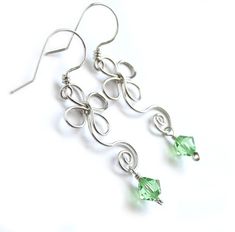 "Whimsical yet elegant earrings are handcrafted from sterling silver filled wire* and your CHOICE of genuine Swarovski crystals, as shown in last photo. These adorable earrings are inspired by the Celtic / Irish shamrock, four leaf-clover, and a multitude of dainty flowers. They would be perfect for spring, St. Patrick's Day, or any time you want to add some charming whimsy to your outfit! Earrings dangle approximately 1.6 inches (4,1 cm) long. Ships gift wrapped as shown in second to last photo Silver Wire Wrapped Crystal Earrings As Gift, Gift Silver Wire Wrapped Crystal Earrings, Silver Wire Wrapped Crystal Earrings For Gift, Silver Crystal Earrings For May Birthstone Gift, Elegant Sterling Silver Wire Wrapped Crystal Earrings, Wire Figures, Shamrock Flower, Christmas Booth, Silver Flower Earrings