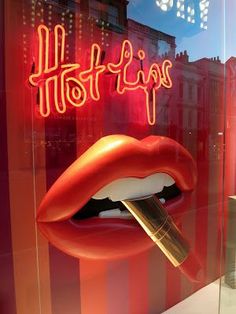 there is a display in the window of a store with red lips and lipstick on it