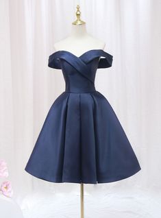 Honor your sophisticated style with this exquisite navy blue homecoming dress. The off-the-shoulder neckline creates a chic and timeless look, perfectly framing your shoulders and collarbone. The bodice is adorned with a unique wrap design that cinches at the waist, providing a flattering and comfortable fit. The full, pleated skirt adds a touch of vintage elegance, allowing for beautiful movement as you dance or walk. The rich navy satin fabric gives the dress a luxurious feel and a subtle sheen, ensuring you stand out in any crowd. This dress combines elegance and comfort, making it perfect for a night of celebration. Ideal for those who appreciate classic beauty with a modern twist, this homecoming dress will make you feel like royalty. Make a lasting impression with this stunning piece Winter Dance Dresses, Off The Shoulder Homecoming Dress, Navy Homecoming Dress, Navy Blue Homecoming Dress, Blue Short Dress, Blue Homecoming Dress, Simple Homecoming Dresses, Blue Dress Short, Blue Homecoming Dresses