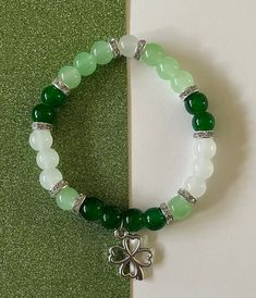 a lucky charm bracelet to add to any fit! Green And Blue Jewelry, Green And White Beaded Bracelet, Cute Green Cheap Friendship Bracelets, Green And White Bracelet, Green Glass Bead Bracelet, Green Glass Beaded Bracelets, White Round Beaded Bracelet For Good Luck, Green Beaded Bracelets For Good Luck, Handmade Green Beaded Bracelets For May Birthstone