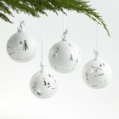 three white ornaments hanging from a christmas tree