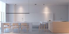 an empty kitchen and dining area with white walls, counter tops and chairs in the foreground