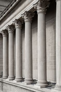 an old stone building with columns and pillars on the front wall in black and white