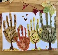 an art project with watercolors on paper and leaves in the shape of trees