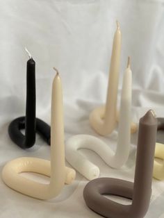 several candles sitting on top of a table next to each other in different shapes and sizes