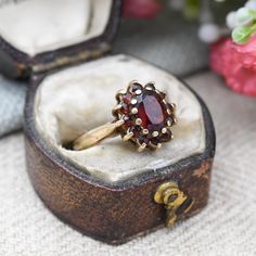 A lovely Mid-Century vintage 9ct gold and garnet floral cluster ring. A wonderful, quality piece of vintage fine jewellery. Stamped with UK hallmarks for 9ct gold to the inside, 1974. In really nice vintage condition. Please be sure to see all of the photos. - UK Size - K - US Size - 5 1/4 - Weight - 2.5 grams -------------------- All boxes and stands in the photographs are for display purposes only, unless otherwise stated. Please be aware there will be marks and wear commensurate with age. Ple Vintage Gold Cluster Ring With Gemstones, Vintage Cluster Ring Suitable For Gifts, Vintage Garnet Birthstone Rings, Vintage 14k Gold Cluster Jewelry, Vintage Gemstone Cluster Ring, Vintage Yellow Gold Cluster Jewelry, Vintage Red Gemstone Cluster Ring, Vintage Red Garnet Cluster Ring, Antique Gemstone Cluster Ring As Gift