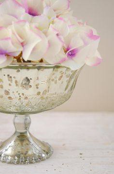 a glass bowl filled with white and pink flowers