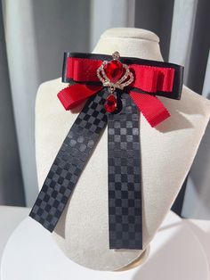 Add a touch of regal charm to your outfit with our rhinestoned crown bow tie/brooch. Available in both black and red, this versatile accessory features a dazzling rhinestone-encrusted crown design that exudes elegance and sophistication. Wear it as a bow tie or use it as a brooch to elevate your look with a hint of royal allure. Perfect for adding a touch of glamour to any outfit, this one-of-a-kind piece is sure to turn heads and make a statement. Whether you're dressing up for a special occasi Black Bow Tie Brooch For Wedding, Black Bow Tie Jewelry For Party, Black Bow Tie Brooches For Wedding, Elegant Red Pins For Party, Elegant Red Jewelry With Bow, Elegant Red Party Pins, Black Brooch With Decorative Bow For Evening, Black Bow Tie Jewelry For Formal Occasions, Formal Black Brooch With Decorative Bow