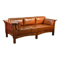 a brown leather couch sitting on top of a wooden table