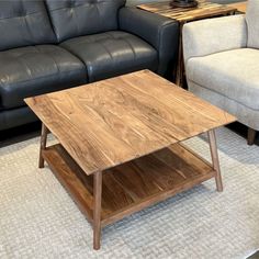 a wooden table sitting on top of a carpeted floor next to two couches