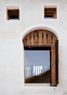 an open window on the side of a white building