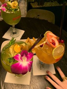 two glasses filled with drinks sitting on top of a table