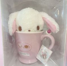 a white stuffed animal in a pink coffee cup