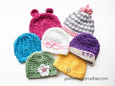 four crocheted hats with bows on them sitting next to each other in different colors