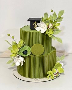 a three tiered green cake with flowers on top