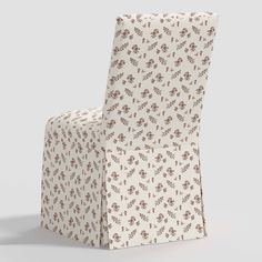 a white and brown chair with a flower pattern on the seat cover that is folded up