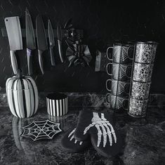 black and white photograph of kitchen utensils on counter top with skeleton hand print