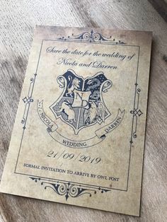 an old harry potter wedding program on a wooden table with the hogwarts crest