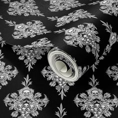 a black and white wallpaper with silver designs on it's surface, including an ornate design