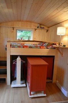 a room with a loft bed and desk in it