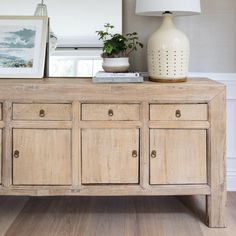 a white vase sitting on top of a wooden dresser