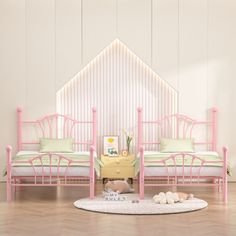 two pink beds sitting next to each other on top of a hard wood floor in front of a white wall