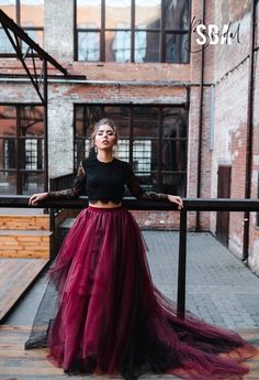 a woman in a black top and red tulle skirt